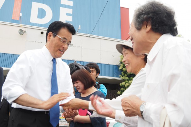 聴衆一人ひとりに「足立候補をよろしく」と握手する岡田代表